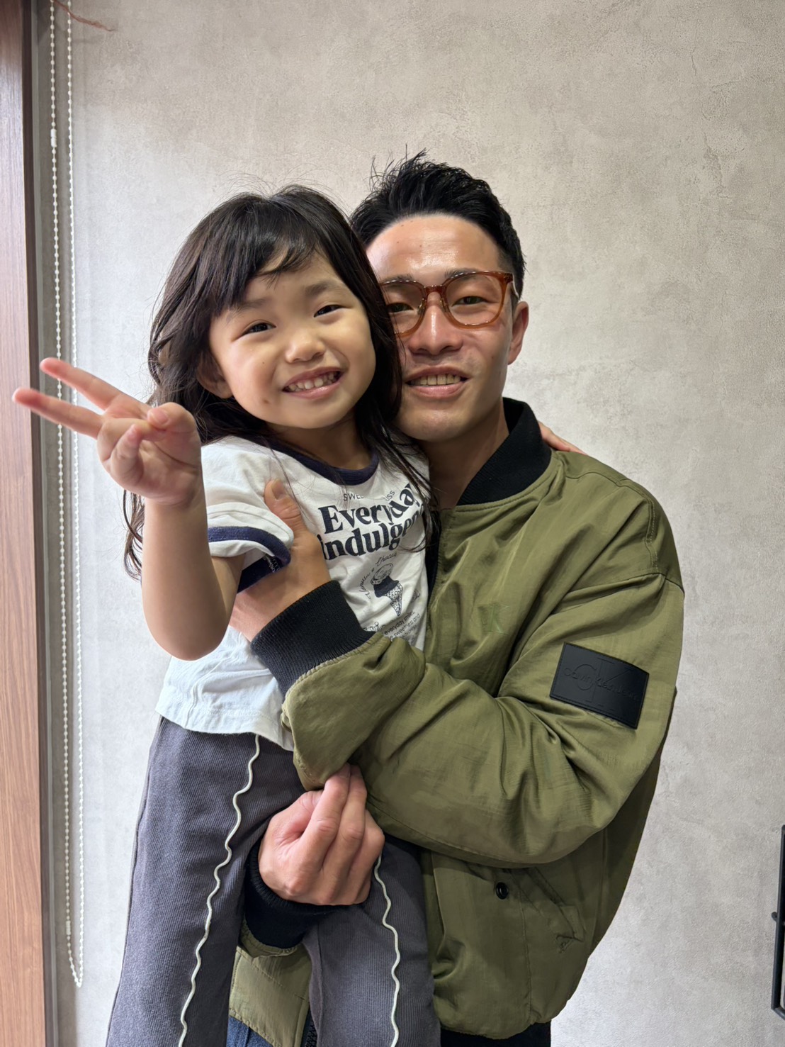 子どもを抱きかかえて笑顔で写る記念写真